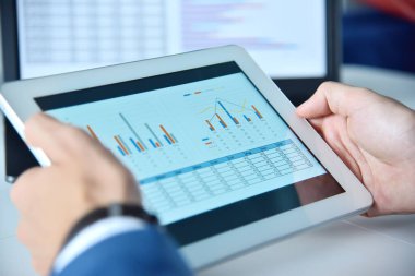 İş raporlu tablet cihazını kullanarak ellerinizi kapatın. İş ve mali başarı kavramı.