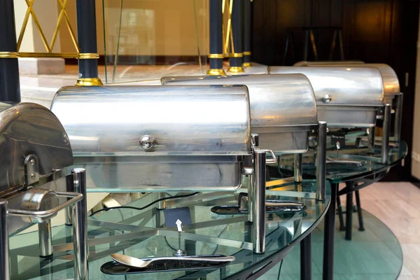 Metal containers with hot food in the restaurant. Self-service