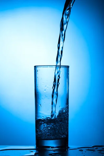 Água Limpa Derrama Close Vidro Fundo Azul — Fotografia de Stock
