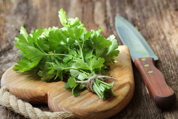 Fresh organic parsley with knife on wooden cutting board. Macro with shallow dof — Stock Photo, Image