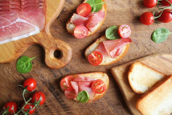 Bruschetta Prosciutto Ham Cherry Tomatoes Green Spinach Top View — Stock Photo, Image