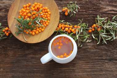 Deniz topalak çilek koyu ahşap arka plan üzerinde şubesi ile çay