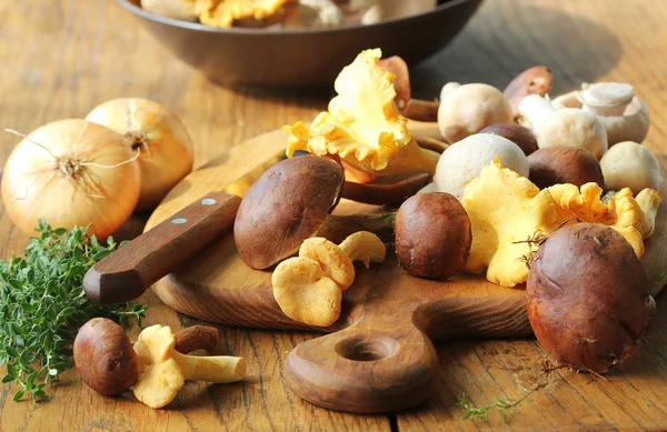 Mix di funghi della foresta sul tagliere sopra il vecchio tavolo di legno — Foto Stock