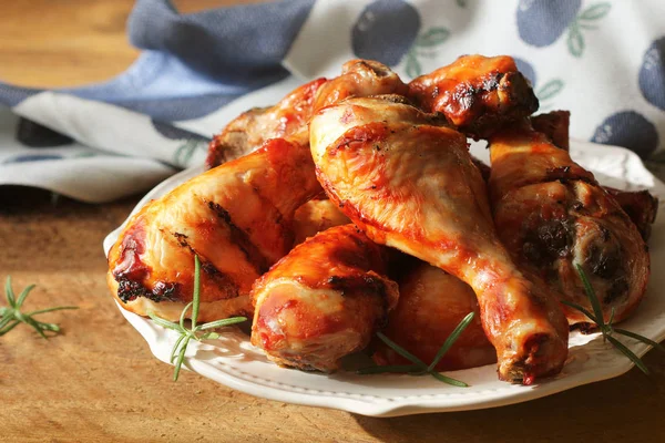 Gegrillte Hühnerkeulen mit Rosmarin auf weißem Teller serviert. Hintergrund des Abendessens — Stockfoto