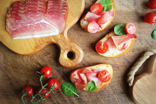 Bruschetta Prosciutto Ham Cherry Tomatoes Green Spinach Top View — Stock Photo, Image