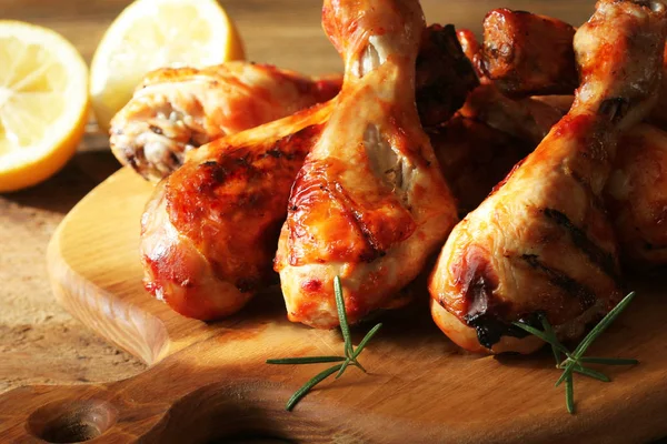 Grilled chicken legs on cutting board. Rustic background — Stock Photo, Image