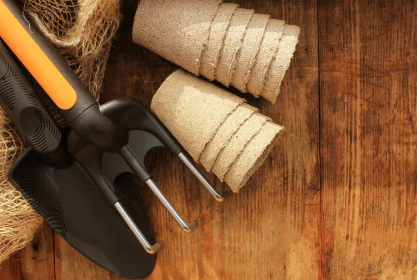 Gardening concept background with garden tools and pots on wooden background. — Stock Photo, Image