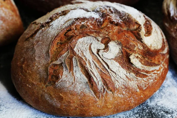 Frisch gebackener hausgemachter Brotlaib auf rustikalem dunklen Hintergrund — Stockfoto