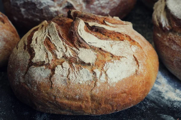 Čerstvě upečený bochník domácího chleba na rustikální tmavé pozadí — Stock fotografie