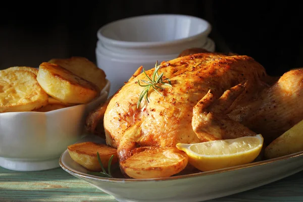 Whole roasted chicken with potatoes and lemon