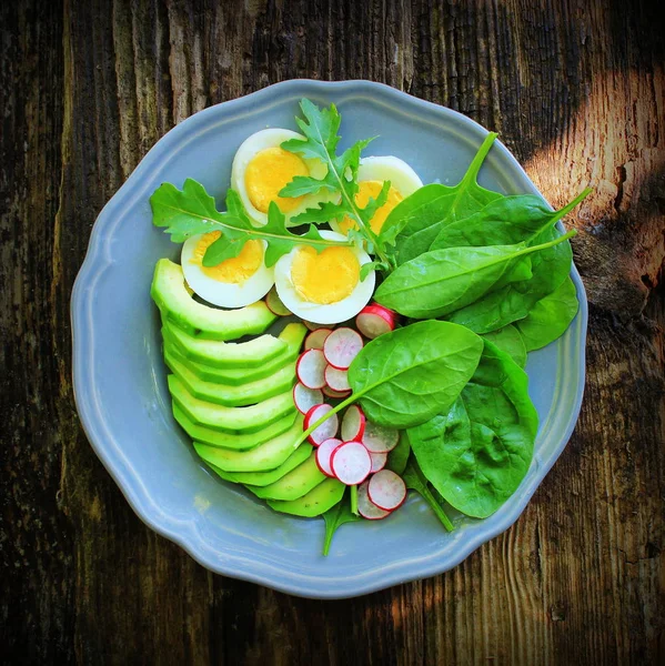 Ontbijt salade met radijsjes, gekookt ei en mix sla bladeren, spinazie. Voedsel achtergrond. Top View — Stockfoto