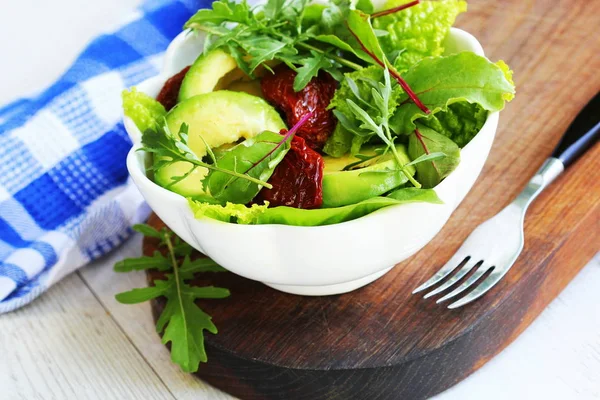 Verse avocado salade met dryy tomaten, sla, rucola bieten bladeren op de witte achtergrond. Gezond voedsel concept. Veganistisch eten. — Stockfoto