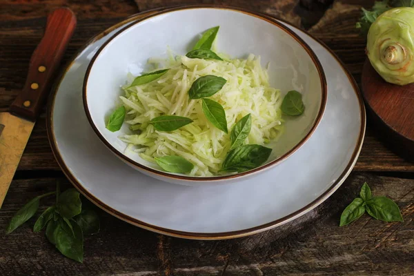 Kohlrabi, parmesan, fesleğen ve susam bir kase içinde dresing ile taze salata. Vejetaryen yemekler