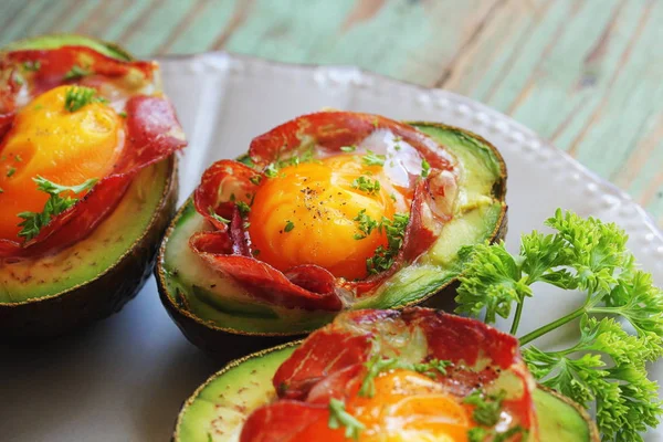 Avocado Egg Boats with bacon on dark wooden background. Top view — Stock Photo, Image