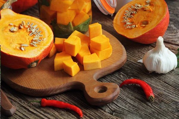 Zucca fresca fatta in casa sottaceto in un bicchiere ed erbe su un tavolo di legno — Foto Stock