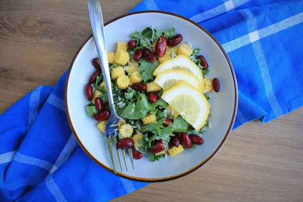 Gezonde rauwe boerenkool en maïs, rode bonensalade met citroen en dressing. Wintersalade. Bovenaanzicht — Stockfoto