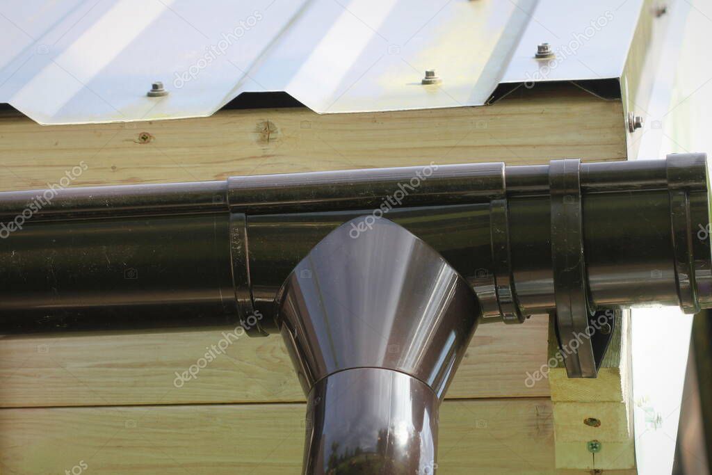 Rain Gutter Pipeline System Installation. Roofing Construction. Rain gutter system and roof protection from snow . Home Guttering, Gutters, Guttering , Drainage Pipe Exterior.