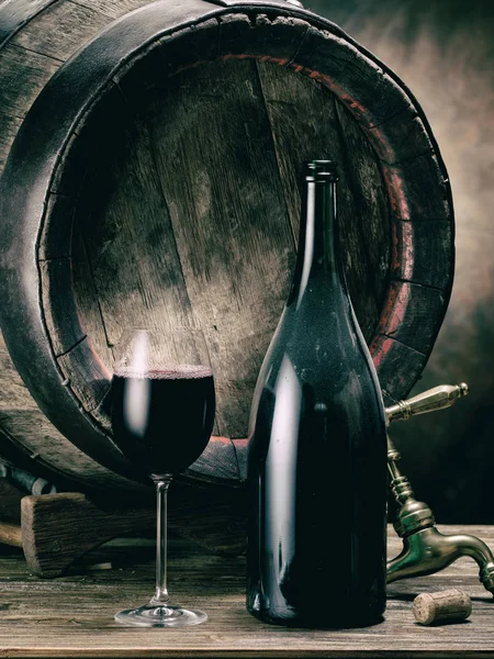 一杯红酒和酒瓶 橡木酒桶在背景 — 图库照片