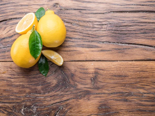 木製の背景に熟したレモンとレモンを残します トップ ビュー — ストック写真