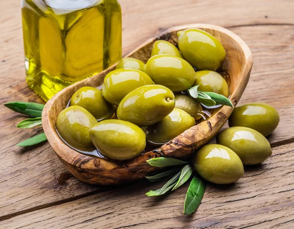 Olivenbeeren Und Eine Flasche Olivenöl Auf Dem Holztisch — Stockfoto