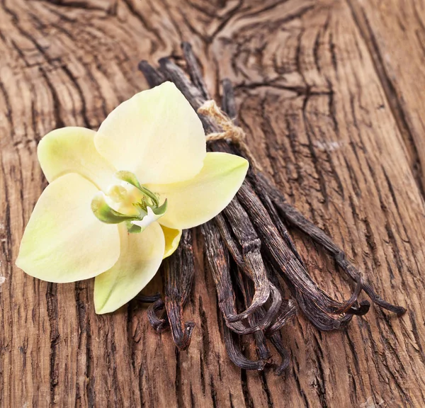 Getrocknete Vanilleschoten Und Orchidee Vanilleblume Auf Hölzernem Hintergrund — Stockfoto