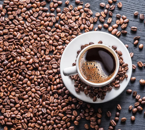 コーヒー豆に囲まれたコーヒー カップ トップ ビュー — ストック写真