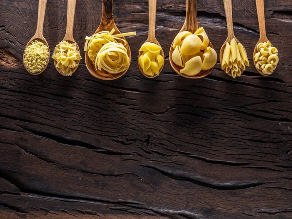 Verschillende Pastasoorten Houten Lepels Tafel Bovenaanzicht — Stockfoto