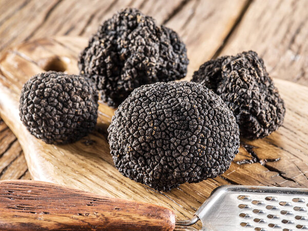 Black truffles on the old wooden table.