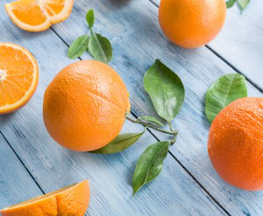 Mavi ahşap masa üzerinde olgunlaşmış portakal.