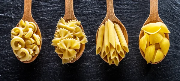 Different Pasta Types Wooden Spoons Table Top View — Stock Photo, Image