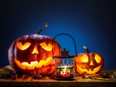 Sırıtan kabak latern veya jack-o'-lantern Cadılar Bayramı sembollerin biridir. Cadılar Bayramı özniteliği. Ahşap arka plan.
