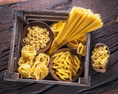 Ahşap masa türlerinde farklı makarna. Üstten Görünüm.