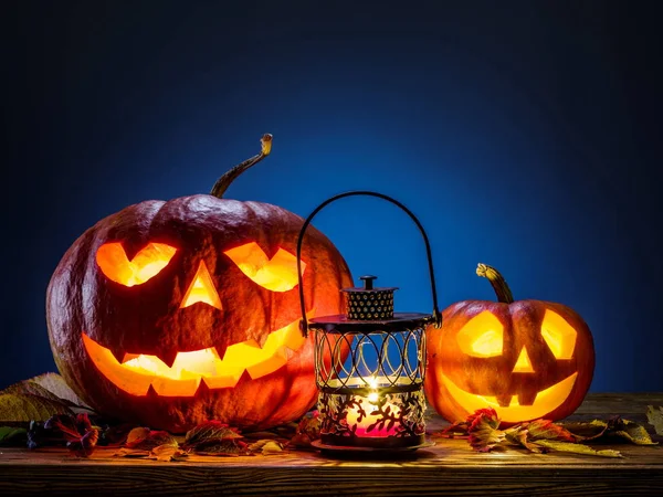 Sırıtan kabak latern veya jack-o'-lantern Cadılar Bayramı sembollerin biridir. Cadılar Bayramı özniteliği. Ahşap arka plan.