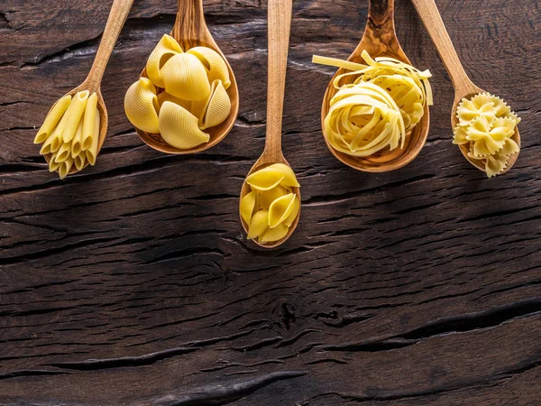 Different Pasta Types Wooden Spoons Table Top View — Stock Photo, Image