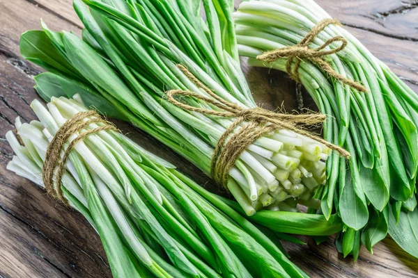Ahşap masa üzerinde genç taze yabani sarımsak.