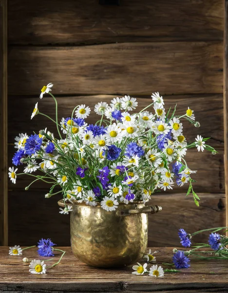 Chamomiles ve Peygamber ahşap masa üzerinde vazoda oluşan.