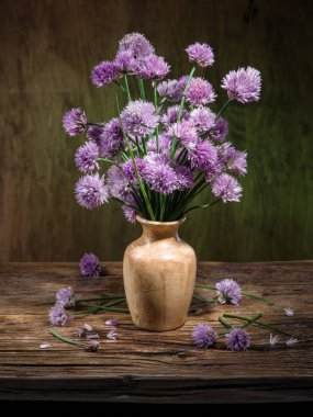 Tahta masadaki vazoda bir buket soğan (soğan soğanı) çiçeği.
