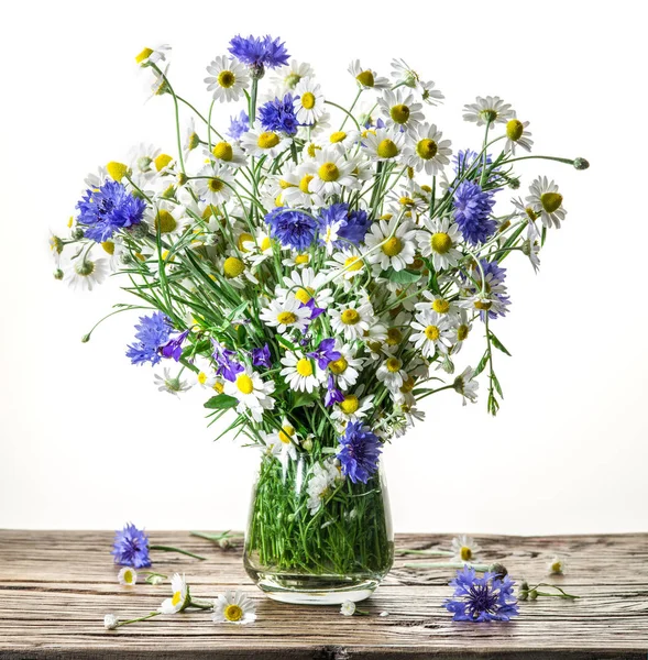 Buket chamomiles ve ahşap masa üzerinde vazoda vereceğim. Beyaz arka plan.
