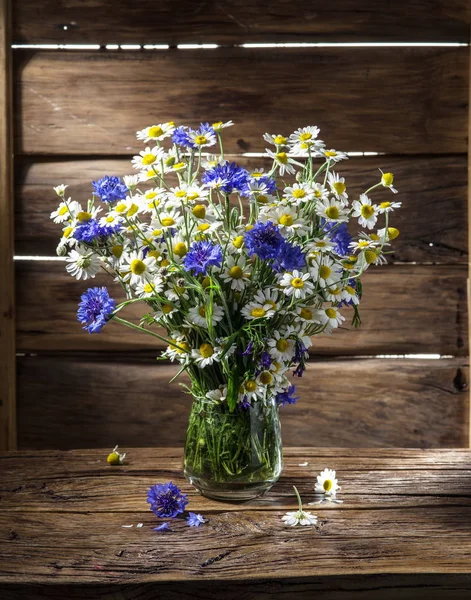 Chamomiles ve Peygamber ahşap masa üzerinde vazoda oluşan.