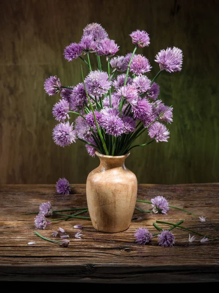 Tahta masadaki vazoda bir buket soğan (soğan soğanı) çiçeği.