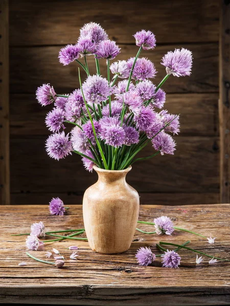 木のテーブルの上の花瓶にタマネギ チャイブ の花の花束 — ストック写真