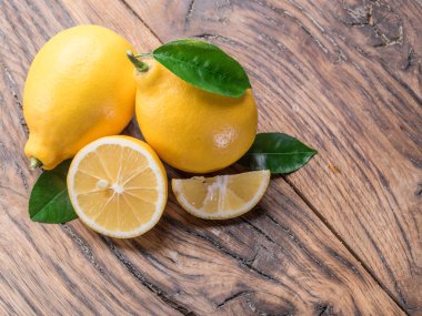 İki olgun limon limon yaprakları eski ahşap tablo ile. Yakın çekim.