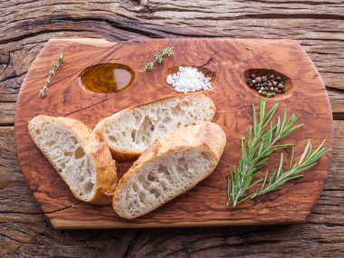 Ciabatta biberiye bitki hizmet ahşap tepsi ile dilim. Üstten Görünüm.