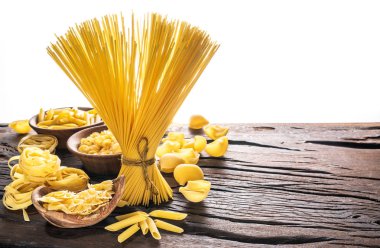 Ahşap masa türlerinde farklı makarna. Beyaz arka plan.