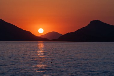 Deniz sahilinde güzel gün batımı. Güneş taşı ayarlama ve güneş ışığı yol su üzerinde bırakarak.