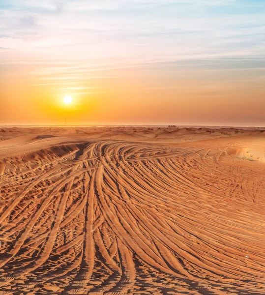 砂漠の夕日にタイヤ踏面で覆われています — ストック写真