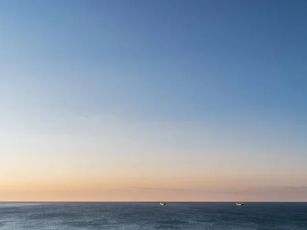 穏やかな海と雲一つないオレンジ色の夕空 — ストック写真
