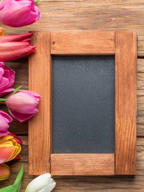 Renkli lale ahşap arka plan karede olarak düzenlenmiştir. Üstten görünüm.