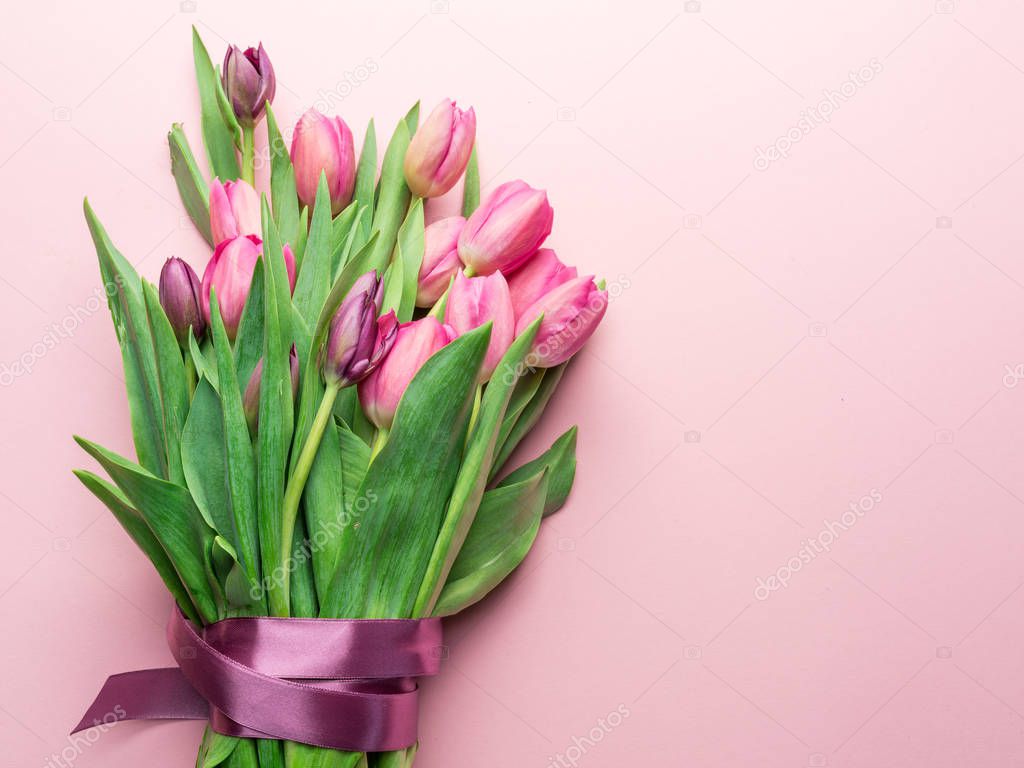 Bouquet pink tulips on lightpink background. Top view.
