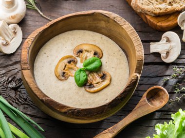 Krem-ahşap masa üzerinde mantar çorbası. Üstten görünüm.